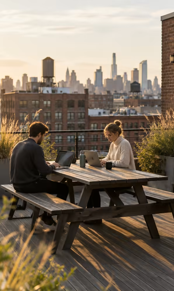 Two members working at a picnic table on the Loft Nine roof terrace.