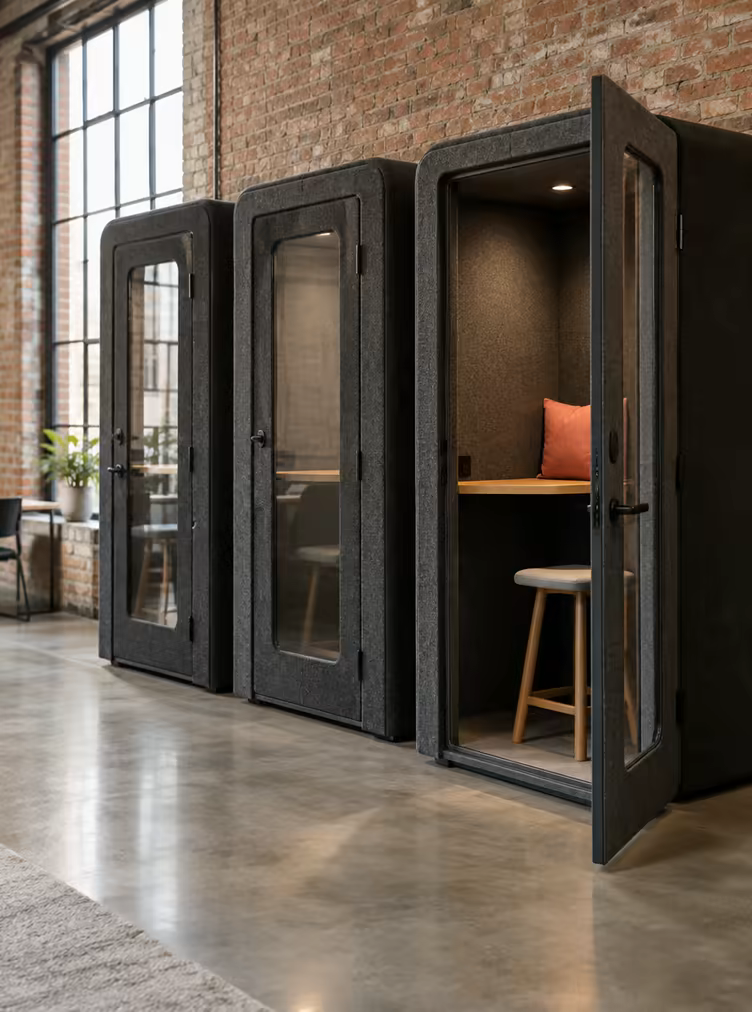 A row of soundproof phone booths clad in charcoal felt on the ground floor at Loft Nine.