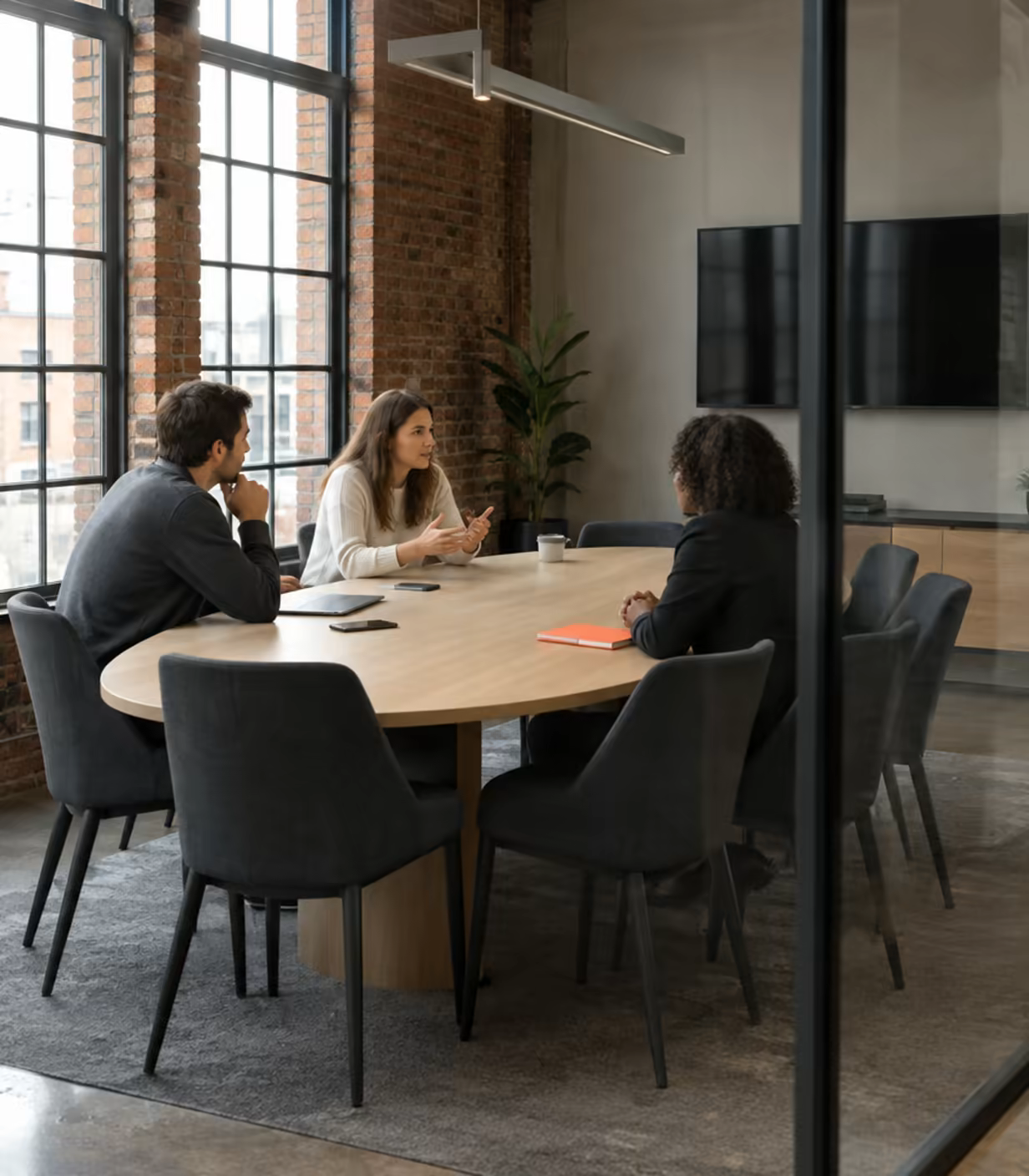 The Press meeting room at Loft Nine, with an oval oak table and a wall screen.