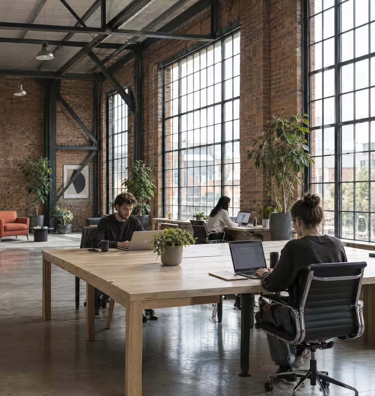 Oak desks beneath tall steel windows on the main floor at Loft Nine.