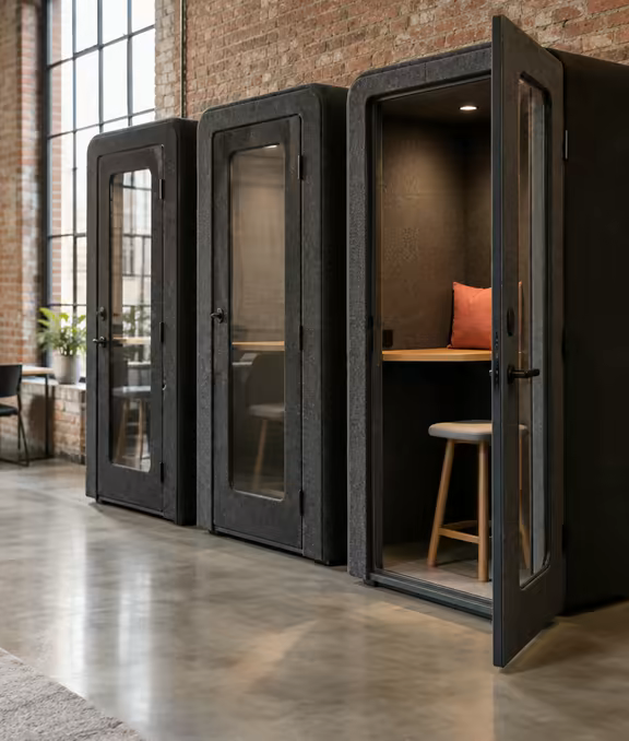 Phone booths clad in charcoal felt on the ground floor at Loft Nine.